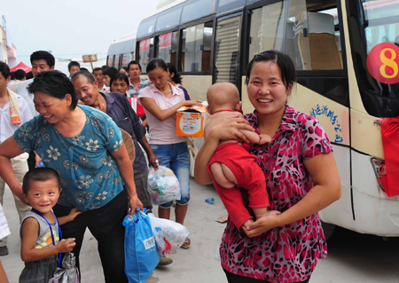 Farmers, relocated for the South-to-North Water Diversion Project, arrive at a newly built village in Xuchang, in central China's Henan province Sunday August 16, 2009. [Xinhua]