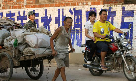 A farmer, affected by the South-to-North Water Diversion Project, carries his belongings to a new village in Xuchang, in central China's Henan province, August 15, 2009.[Asianewsphoto]