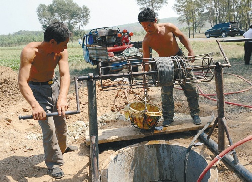 Farmers fetch water from a well dug by themselves in Fuxin Mongolia Autonomous County, Fuxin city, northeast China's Liaoning Province, Aug. 14, 2009. [Shenyang Daily]