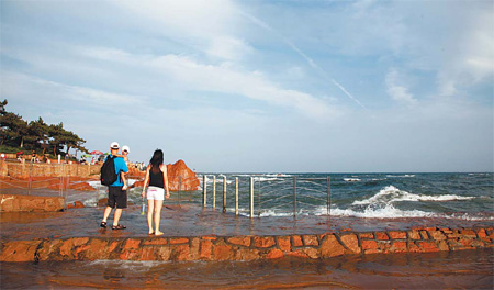 People stroll along the beach at Qingdao. The city of Shandong province built a seawater desalination pilot project to save water resources. [CFP]