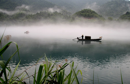 The photo taken on Aug. 16, 2009 shows the beautiful foggy scenery on the Xiaodongjiang River in Zixing City of central China's Hunan Province. The dreamlike foggy scenery along foggy Xiaodongjiang River from April to October every year attracts a lot of tourists and photographers. [Liu Aicheng/Xinhua]
