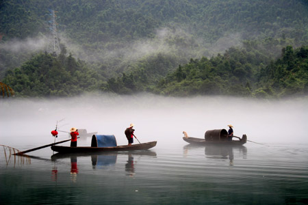 The photo taken on Aug. 16, 2009 shows the beautiful foggy scenery on the Xiaodongjiang River in Zixing City of central China's Hunan Province. The dreamlike foggy scenery along foggy Xiaodongjiang River from April to October every year attracts a lot of tourists and photographers. [Liu Aicheng/Xinhua]