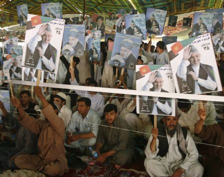 Afghan men hold posters of Afghanistan's President Hamid Karzai during an election rally in support of Karzai, who is seeking a second term in the country's upcoming presidential election, in Kandahar province August 16, 2009.