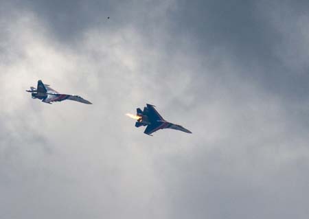 An undamaged Su-27 jet (L) follows the burning Su-27, just seconds after the burning aircraft (R) collided with a two-seat Su-27 (not seen) not far from the Zhukovsky airfield, east of Moscow, Sunday, Aug. 16, 2009. Two Russian air force jets rehearsing aerobatic maneuvers collided Sunday near Moscow, killing one stunt pilot and sending one fighter crashing into nearby vacation homes, a military official said.