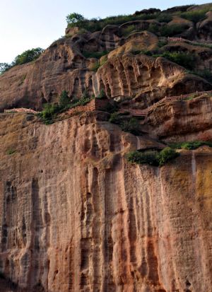 Photo taken on Aug. 14, 2009 shows craggedness of the cliffs in the Huoshizhai National Geopark in northwest China's Ningxia Hui Autonomous Region. The geopark is famous for its unique 'Danxia' landform. Danxia, which means 'rosy cloud', is a kind of special landform formed from reddish sandstone that has been eroded over time into a series of mountains surrounded by curvaceous cliffs and many unusual rock formations. (Xinhua/Liu Quanlong)