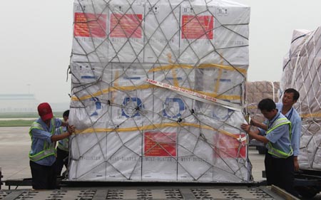 Working staff examine the relief supplies at the Beijing Capital International Airport, China, on Aug. 18, 2009. (Xinhua/Xing Guangli)