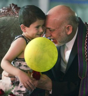 Afghan presidential candidate President Hamid Karzai (R) talks to a child during the opening ceremony for a new hospital in Kabul August 16, 2009.  Afghanistan's presidential election will be held on August 20.