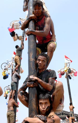 Contestants help one another to climb greasy poles to reach prizes hung at the top during the celebrations of Indonesia's Independence Day in Jakarta Aug. 17, 2009. Indonesia on Monday celebrated its 64th anniversary of independence. (Xinhua/Yue Yuewei) 