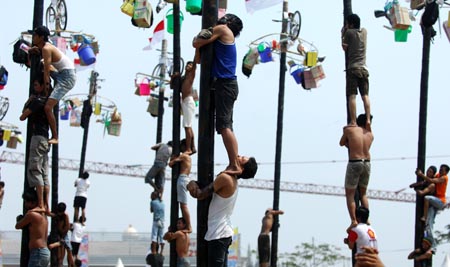 Contestants help one another to climb greasy poles to reach prizes hung at the top during the celebrations of Indonesia's Independence Day in Jakarta Aug. 17, 2009. Indonesia on Monday celebrated its 64th anniversary of independence. (Xinhua/Yue Yuewei)
