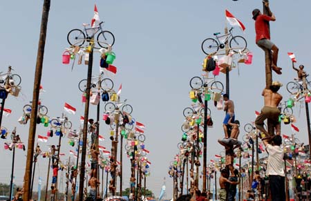 Contestants help one another to climb greasy poles to reach prizes hung at the top during the celebrations of Indonesia's Independence Day in Jakarta Aug. 17, 2009. Indonesia on Monday celebrated its 64th anniversary of independence. (Xinhua/Yue Yuewei)