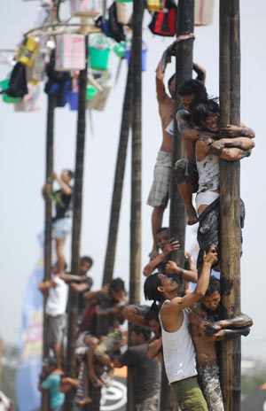 Contestants help one another to climb greasy poles to reach prizes hung at the top during the celebrations of Indonesia's Independence Day in Jakarta Aug. 17, 2009. Indonesia on Monday celebrated its 64th anniversary of independence. (Xinhua/Yue Yuewei)