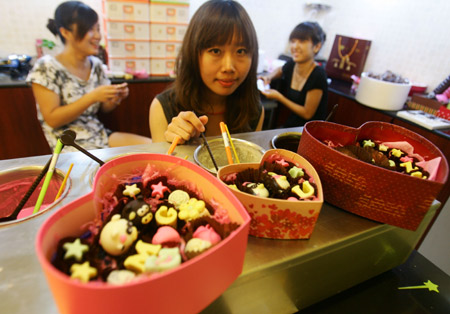 Women customers try to make their own style chocolates for the coming Chinese Valentine's Day at a handicraft chocolate shop in downtown Hangzhou, east China's Zhejiang province, August 18, 2009.