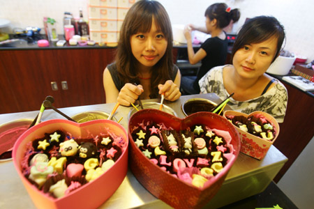 Women customers try to make their own style chocolates for the coming Chinese Valentine's Day at a handicraft chocolate shop in downtown Hangzhou, east China's Zhejiang province, August 18, 2009. These fashionable women will welcome the Chinese Valentine's Day on August 26, 2009 with their individual style chocolates for their lovers.