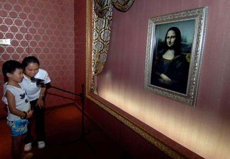 A child communicates with a digital version of Mona Lisa at an exhibition in Beijing, capital of China, Aug. 18, 2009. The exhibition displayed many masters' paintings in digital version, which demonstrated stories behind the masterpieces through interactive multimedia technology.