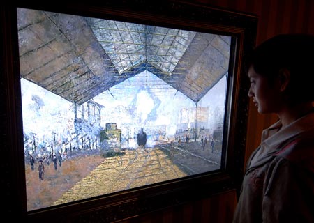 A visitor watches a digital version of the painting La Gare Saint-Lazare at an exhibition in Beijing, capital of China, Aug. 18, 2009. The exhibition displayed many masters' paintings in digital version, which demonstrated stories behind the masterpieces through interactive multimedia technology.