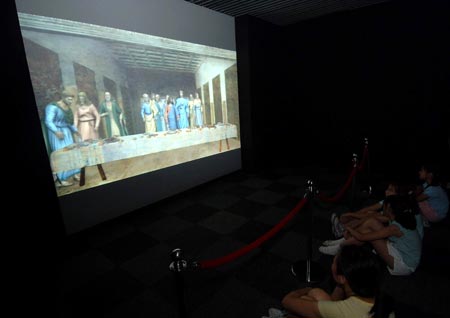 Visitors watch a digital version of Leonardo da Vinci's Last Supper at an exhibition in Beijing, capital of China, Aug. 18, 2009. The exhibition displayed many masters' paintings in digital version, which demonstrated stories behind the masterpieces through interactive multimedia technology.