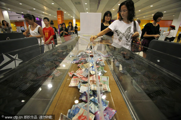 Attendees place money in donation boxes before the start of the 'Artistes 88 Fund Raising Campaign' at the AsiaWorld-Expo in Hong Kong Monday, Aug. 17, 2009. Over 100 artists from Mainland China, Hong Kong and Taiwan are taking part in the fundraiser to benefit flood victims in Taiwan.