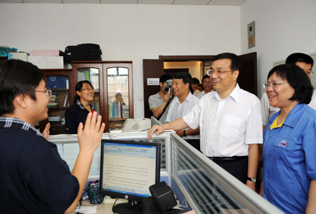 Chinese Vice Premier Li Keqiang (2nd R) talks with scientists and researchers as he visits Chinese Academy of Geological Sciences, in Beijing, capital of China, Aug. 17, 2009. 