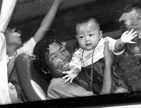 A baby waves goodbye to his hometown before being relocated on Sunday in Xichuan county, Danjiangkou, Henan province. Niu Shupei 