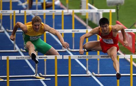 Shi Dongpeng (R) of China competes in the first round of Men's 110M Hurdles in the 12th IAAF World Championships in Athletics in Berlin, Germany, Aug. 19, 2009. Shi Dongpeng was qualified to the next round with 13.56 seconds.