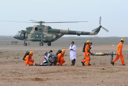 Members of medical team rescue the 'injured person' during a medical support drill in the remote northwestern Helan Mountains, Ningxia Hui Autonomous Region, Aug. 19, 2009. (Xinhua/Han Chuanhao)
