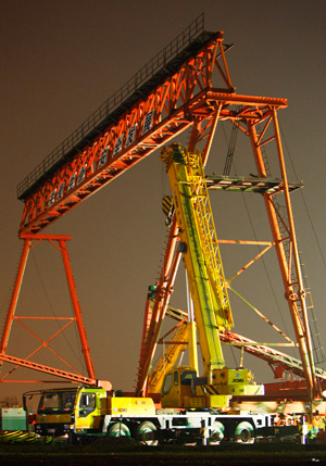 A construction vehicle is doing the clearing operations at the accident site after a 10-tonne gantry crane collapsed at a construction site of the Beijing-Shanghai High-speed Railway in Jiading District of Shanghai, east of China, Aug. 19, 2009. A total of four workers died and another two were injured at the accident.(Xinhua/Pei Xin)