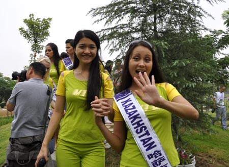 Two contestants for 2009 Miss Tourism International perform their pageant show at a city park in Luohe city, central China's Henan province, August 19, 2009. Some 120 contestants from around the world attended the pageant show on Wednesday. (Xinhua/Cheng Yuefeng)