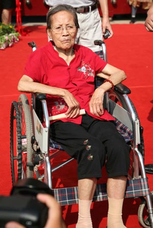 A 100-year-old visitor in wheelchair gets through the main gate of Xuanwumen, the main entrance of the 100-year-old Xuanwuhu park in Nanjing, east China's Jiangsu province, August 19, 2009. Thousands of people came to the park for free visit in the festivities for 100th aniversary celebration. (Xinhua/Wang Xin) 