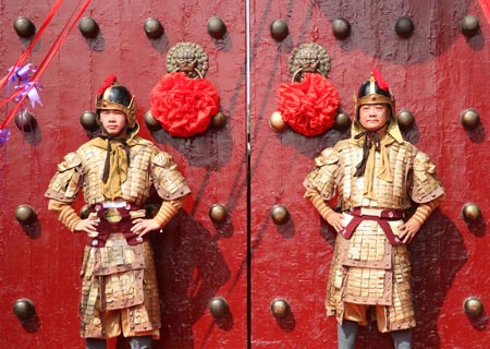 Two guards in ancient uniforms stand at the main gate of Xuanwumen, the main entrance of the 100-year-old Xuanwuhu park in Nanjing, east China's Jiangsu province, August 19, 2009. Thousands of people came to the park for free visit in the festivities for 100th aniversary celebration. (Xinhua/Wang Xin)