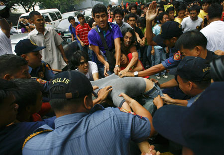 Student protesters hold one of their classmates as police try to arrest him upon reaching the gates of the Malacanang compound in suburban Manila, Aug. 19, 2009. More than a dozen protesters were arrested and some injured as they scuffled with police while breaching through security gates during a demonstration against alleged corruption in the government of Philippine President Gloria Macapagal-Arroyo.(Xinhua/Luis Liwanag)