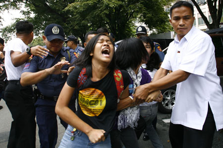 Policemen arrest a student protester during a scuffle as protesters reached the gates of the Malacanang compound in suburban Manila, Aug. 19, 2009. More than a dozen protesters were arrested and some injured as they scuffled with police while breaching through security gates during a demonstration against alleged corruption in the government of Philippine President Gloria Macapagal-Arroyo.(Xinhua/Luis Liwanag)