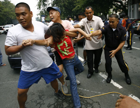 Policemen arrest a student protester during a scuffle as protesters reached the gates of the Malacanang compound in suburban Manila, Aug. 19, 2009. More than a dozen protesters were arrested and some injured as they scuffled with police while breaching through security gates during a demonstration against alleged corruption in the government of Philippine President Gloria Macapagal-Arroyo.(Xinhua/Luis Liwanag)