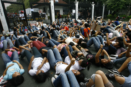 Protesters lie on the ground in front of the gates of the Malacanang compound in suburban Manila, Aug. 19, 2009. More than a dozen protesters were arrested and some injured as they scuffled with police while breaching through security gates during a demonstration against alleged corruption in the government of Philippines President Gloria Macapagal-Arroyo.(Xinhua/Luis Liwanag)(