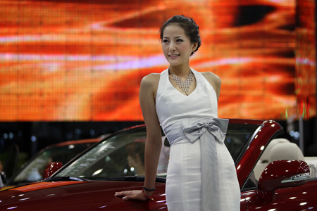 A model shows a car on the international automotive industry exhibition in Dalian, a coastal city of northeast China's Liaoning Province, Aug. 19, 2009. The 14th Dalian Automotive Industry Exhibition, with 530 companies from 13 countries and regions participating, opened in Dalian on Wednesday and would last until Aug. 23. (Xinhua/Lu Guozhong)