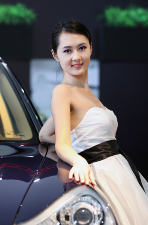 A model shows a car on the international automotive industry exhibition in Dalian, a coastal city of northeast China's Liaoning Province, Aug. 19, 2009. (Xinhua/Lu Guozhong) 