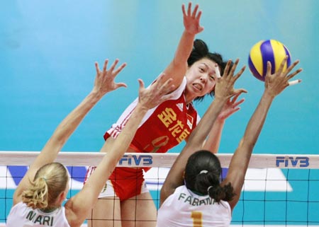 China's Zhao Yanni (C) spikes the ball as Brazil's Marianne Steinbrecher (L) and Fabiana Claudino (R) try to block during the second round match of 2009 FIVB World Grand Prix women's volleyball final in Tokyo on August 20, 2009. China lost 0-3.