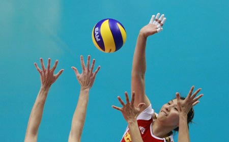 China's Li Juan spikes the ball as Brazil's Thaisa Menezes (L)and Danielle Lins (R) (not seen in the picture) try to block during the second round match of 2009 FIVB World Grand Prix women's volleyball final in Tokyo on August 20, 2009. China lost 0-3.