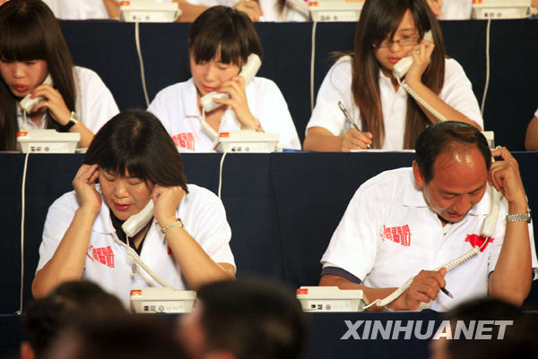 Volleyball coach Lang Ping (L, front) and Sun Haiping (R, front), head coach of China's Olympic and world champion Liu Xiang, work as operators for donation during a television fundraiser in Beijing, capital of China, on Aug. 20, 2009.[Li Mingfang/Xinhua] 