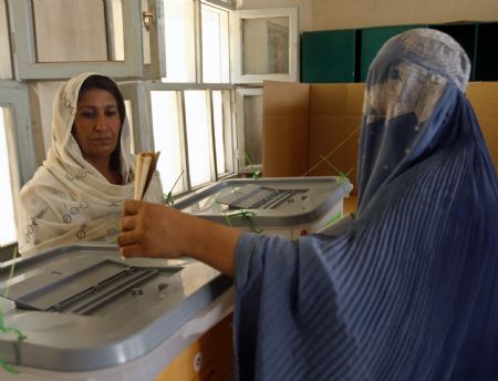 A burqa-clad Afghan woman casts her vote at a polling station in the southern Afghan city of Kandahar, August 20, 2009.[Xinhua/Reuters]