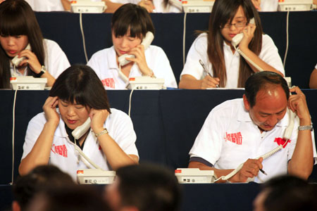 Volleyball coach Lang Ping (L, front) and Sun Haiping (R, front), head coach of China's Olympic and world champion Liu Xiang, work as operators for donation during a television fundraiser in Beijing, capital of China, on Aug. 20, 2009.[Li Mingfang/Xinhua] 