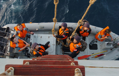 Chinese naval soldiers climb down the ladder from the larboard of Zhoushan missile frigate of the Chinese escort flotilla to the yacht to protect merchant vessel 'Zhenhua 14' from pirates in the Aden Gulf, Aug. 20, 2009. The Chinese escort flotilla is on their mission of protecting the Chinese merchant ship 'Zhenhua 14' in the Gulf of Aden on Aug. 20.[Xinhua]