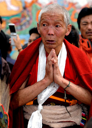 A local prays during the Buddha Thangka painting unfolding ceremony at Sera Monastery in Lhasa, capital of southwest China's Tibet Autonomous Region, on Aug. 20, 2009.[Chogo/Xinhua]