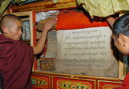File photo taken in June 2005 shows monks checking a book on Buddhism at the Sagya Monastery, southwest China's Tibet Autonomous Region. (Xinhua/Soinam Norbu)