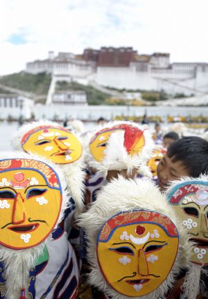 Local kids with ethnical masks attend a ceremony to celebrate the success of repair work on the public square in front of the Potala Palace in Lhasa, southwest China's Tibet Autonomous Region, Aug. 23, 2009.(Xinhua/Purbu Zhaxi) 