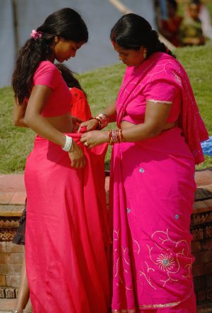 A mother helps her daughter wear her saree at the Pashupati Nath Temple during celebrations of the 'Teej' festival in Kathmandu August 23, 2009.[Xinhua/Reuters]