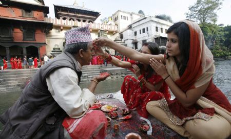 Women at Pashupati Nath Temple perform rituals in celebration of the 'Teej' festival in Kathmandu August 23, 2009.[Xinhua/Reuters]