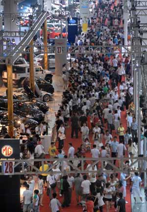 Visitors look at vehicles during the Dalian International Automotive Industry Exhibition held at Dalian World Expo Center in Dalian, a coastal city of northeast China's Liaoning Province, Aug. 23, 2009. The five-day Dalian International Automotive Industry Exhibition ended on Sunday with the total trade amount reached nearly 1.4 billion yuan. [Xinhua]