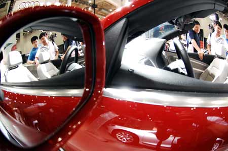 Visitors look at vehicles during the Dalian International Automotive Industry Exhibition held at Dalian World Expo Center in Dalian, a coastal city of northeast China's Liaoning Province, Aug. 23, 2009.[Xinhua]