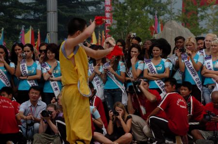 The contestants of Miss Tourism Queen International 2009 view the performance of martial arts at the Shaolin Temple, central China's Henan Province, Aug. 23, 2009. [Xinhua]