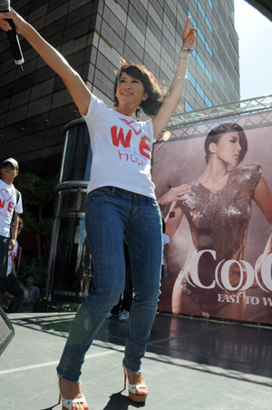 Pop singer Coco Lee attends a promotion event of her new album in Taipei, southeast China's Taiwan Province, Aug. 23, 2009, during which she raises donations for the typhoon Morakot hit area in Taiwan by rummage sales of T-shirts designed by herself with a designing group. [Wu Ching-teng/Xinhua]